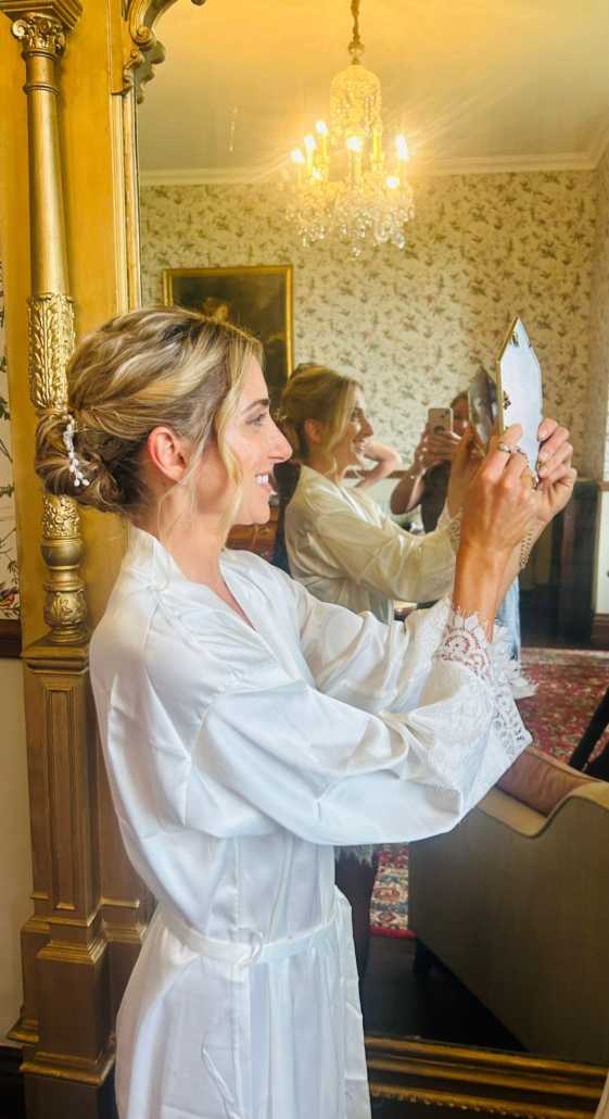 Bridal hair-up being finished in a hand mirror